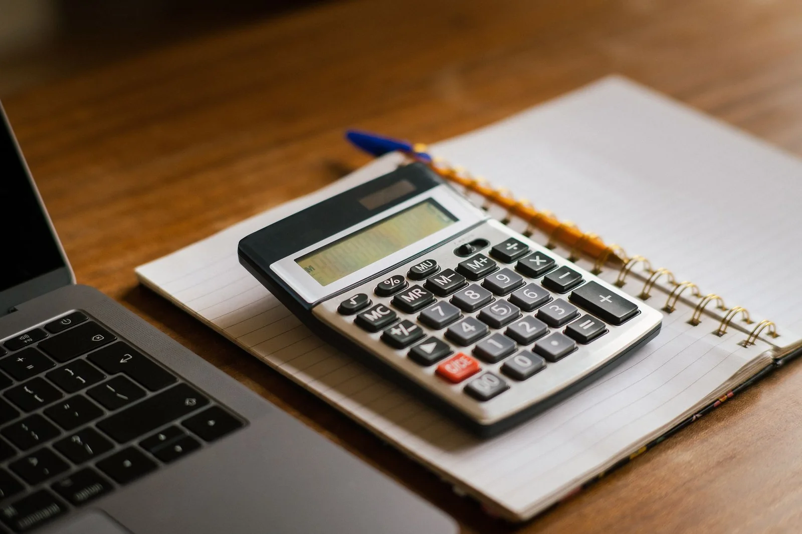 Calculatrice, carnet de notes et clés posés sur une table pour préparer un budget d'achat immobilier